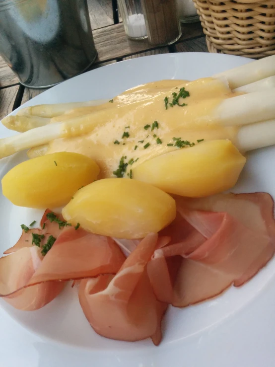 plate with meats and potatoes, garnished with a sauce