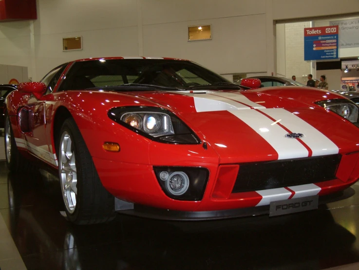 the car is parked in the showroom with people