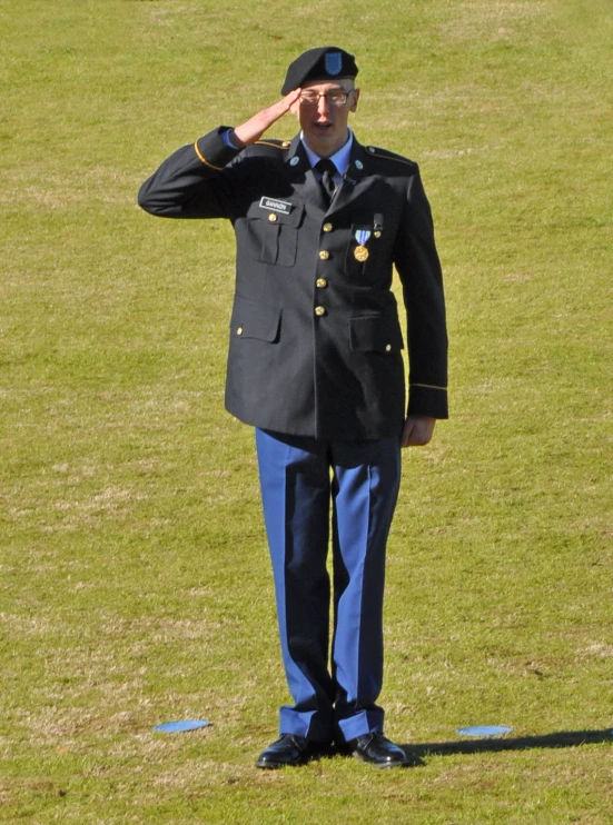 a person in uniform saluting in the park