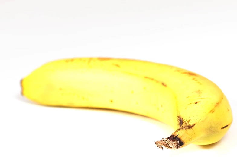 a ripe banana sitting on top of a white surface