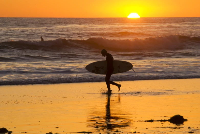 a person is walking along the beach in front of the ocean