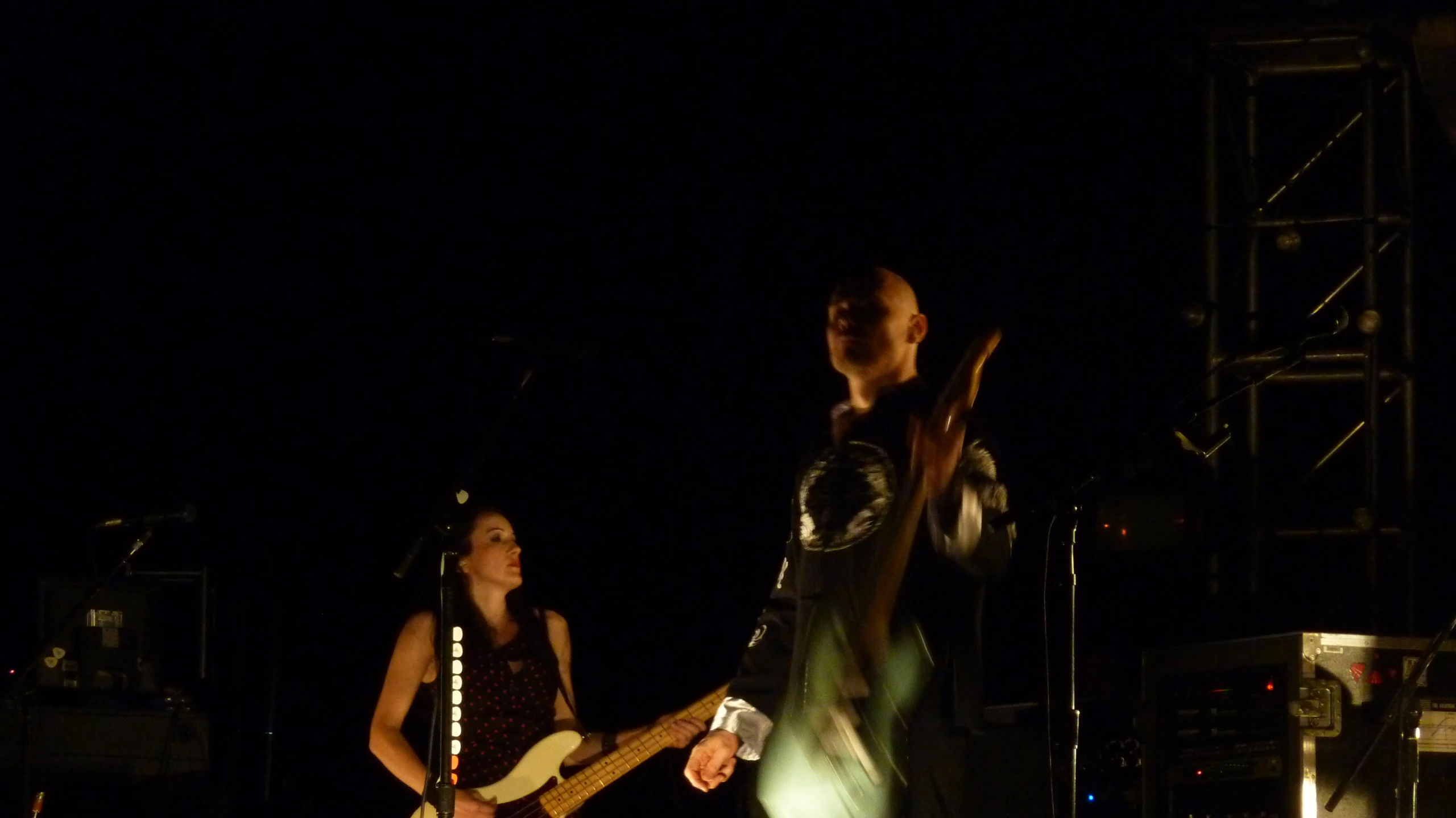 a man holding a guitar playing while a woman holds it