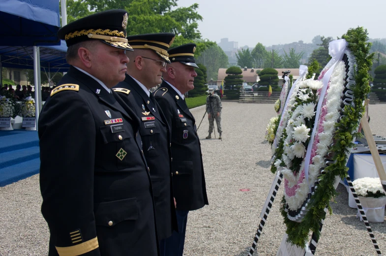 some men in uniforms standing in front of a flag laying