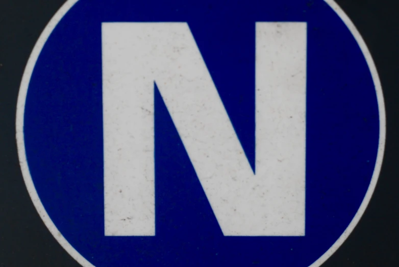 blue and white sign with letters n and a capital in the upper corner