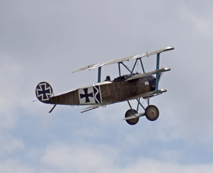 an old airplane flying in the blue sky