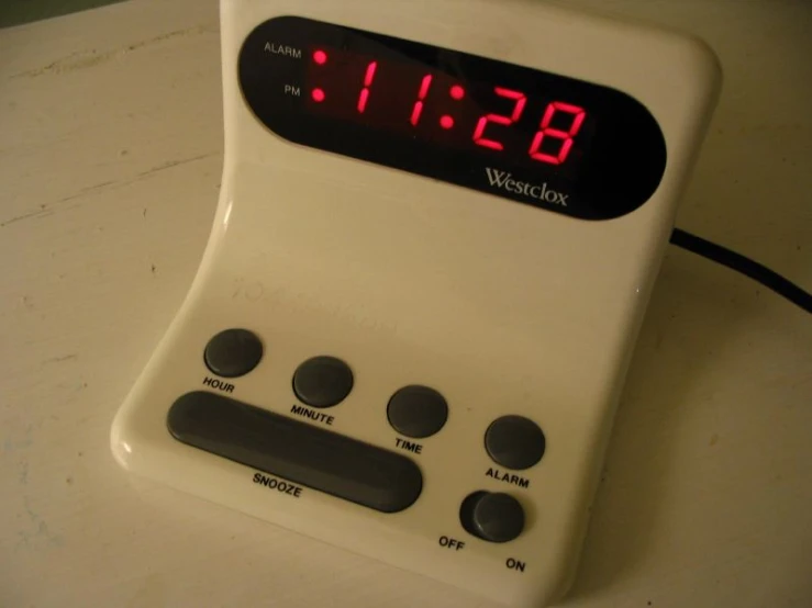 a white electronic clock on top of a counter