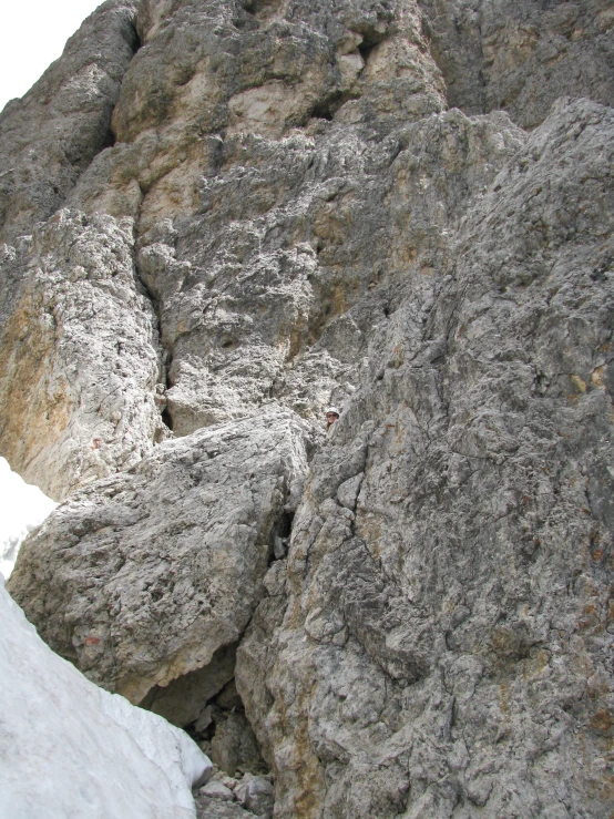 the face of a mountain climb with snow on it