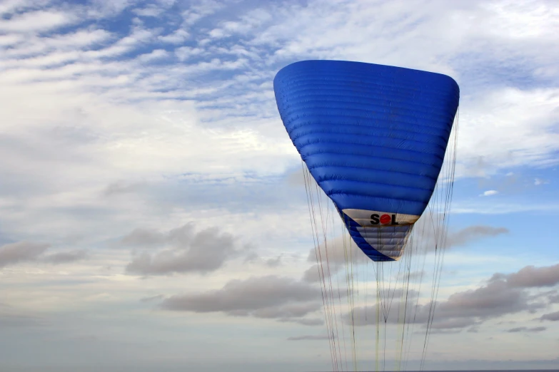 a large balloon floating in the air with a blue cover over it