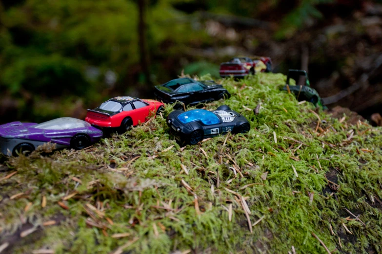 several little toy cars are sitting in the grass