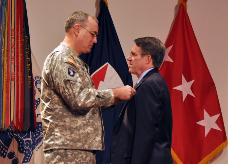 a soldier shaking hands with another soldier at a podium