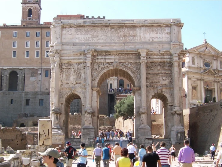 many people are walking around in front of an ancient structure