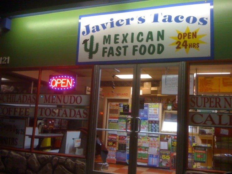 a mexican fast food restaurant is lit up at night