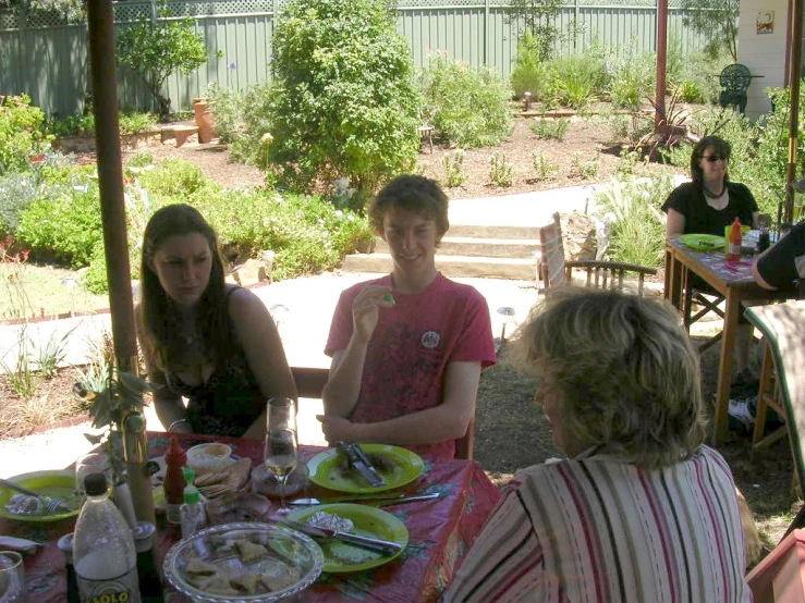 a group of people eating dinner at an outside table