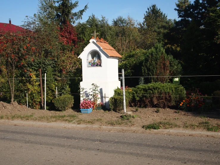 a small white building on the side of a road