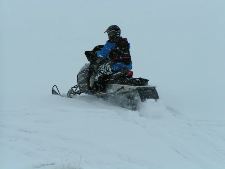 a person on a snow mobile riding through the snow