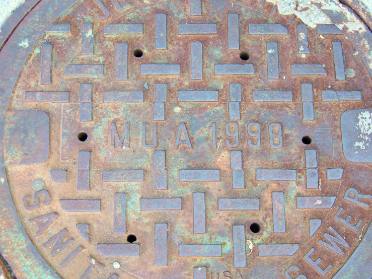 a manhole with an over head metal cover has a sign that reads'here is there water '