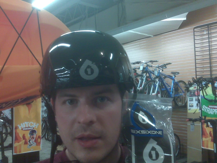 a young man wearing a helmet next to a bike shop