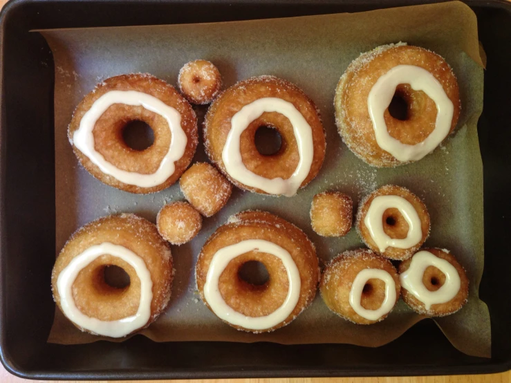the donuts are sprinkled with icing in the pan