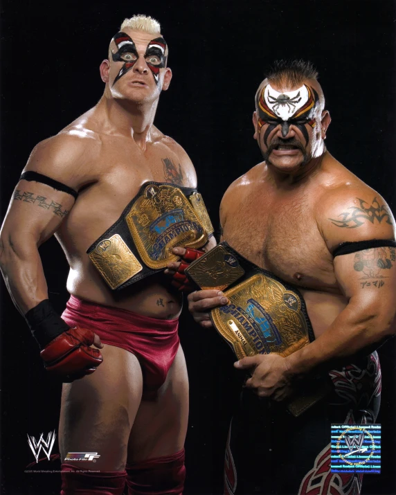 a close up of two people standing next to each other holding sumo belts