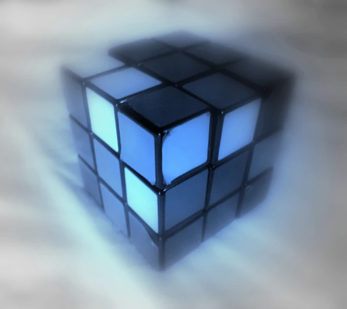 a black and blue cube sitting on top of a white surface