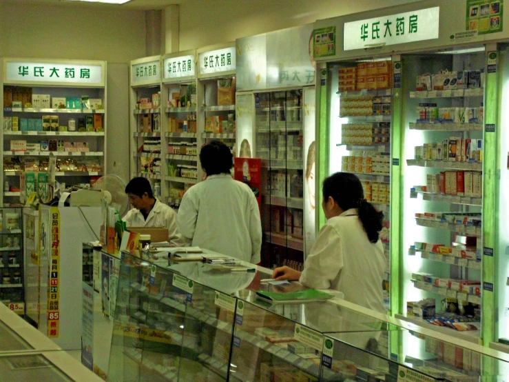 customers look over the cash register at an asian pharmacy