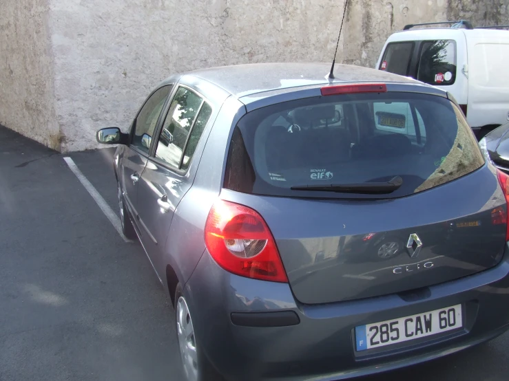 a grey car parked next to a wall