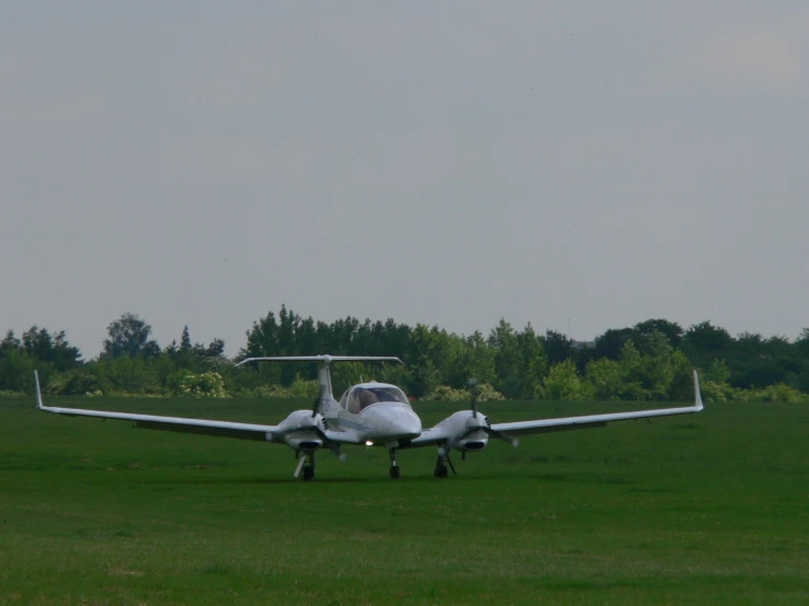 an airplane sitting on the runway on the grass