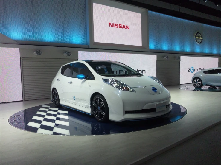 three white nissan electric cars sitting on display