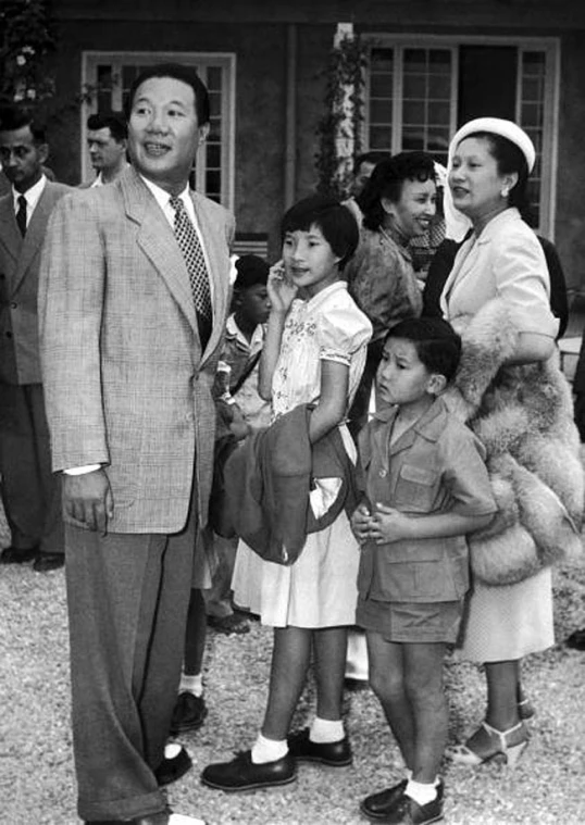 a black and white po of people in front of a house