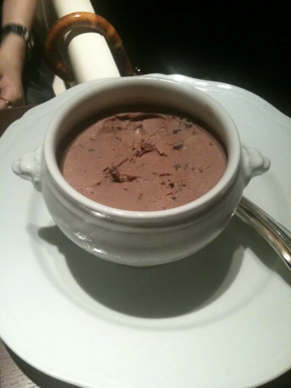 a cup of chocolate ding sitting on top of a plate