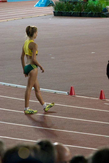 a girl in a bikini and yellow shirt on a track