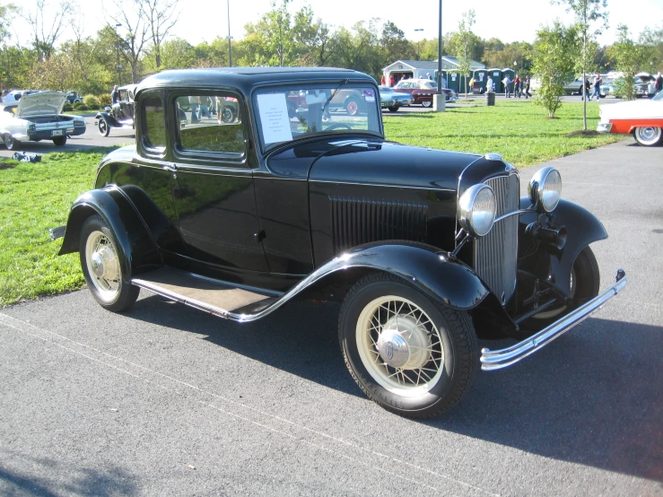 an antique black ford sedan is parked on the pavement