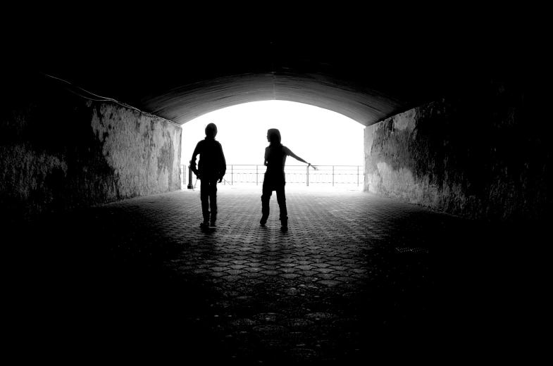 a couple walking out from under an open tunnel