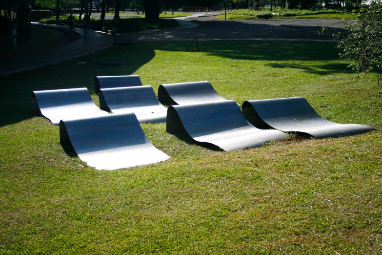 six skateboards laying on the grass near each other