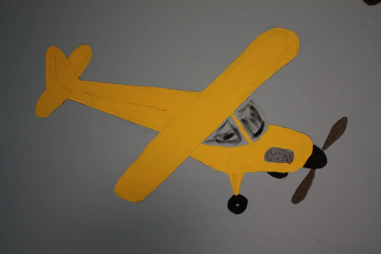 an art display with a yellow biplane with grey paint