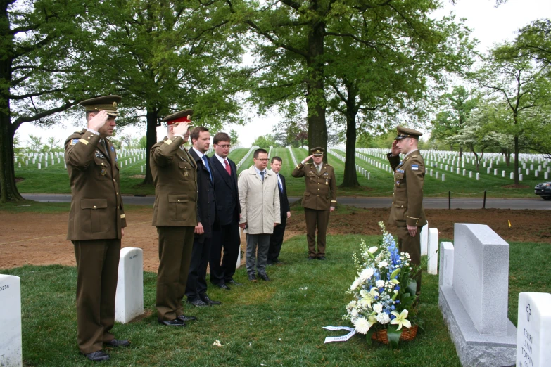 men and women in uniforms are standing near tombstones