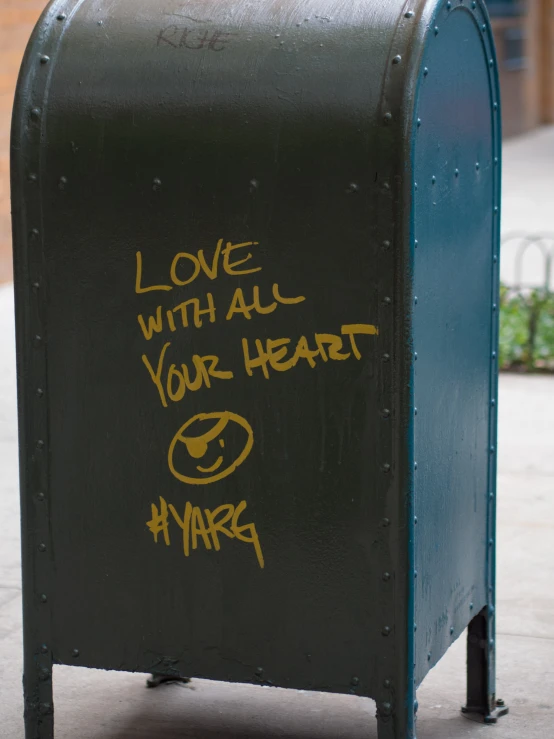 a box on a sidewalk with the word love with all your heart written on it