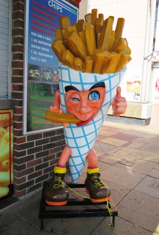 a statue of a person is in a basket of fries