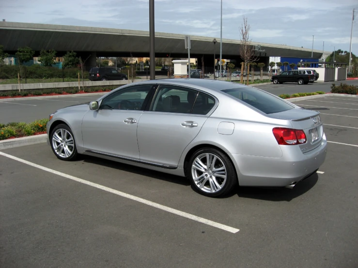 a silver car is parked in the middle of a parking lot