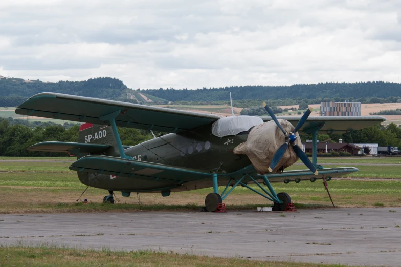 an old propeller plane with it's wheels turned on