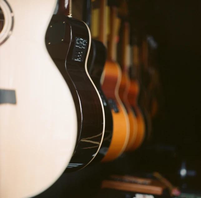 guitars lined up in a rack with musical instruments in the background