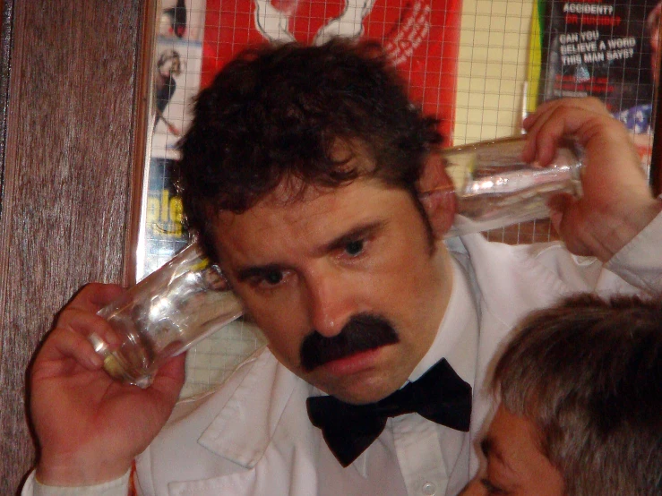 a man with a mustache and mustache is drinking soing