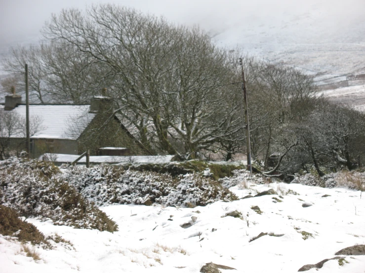 this is a snow covered house in the country side