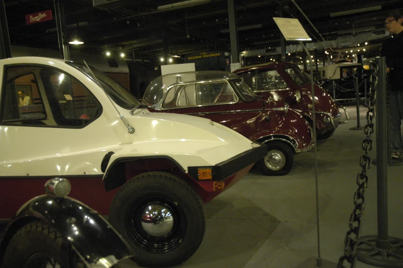 three old cars are on display at an automobile show