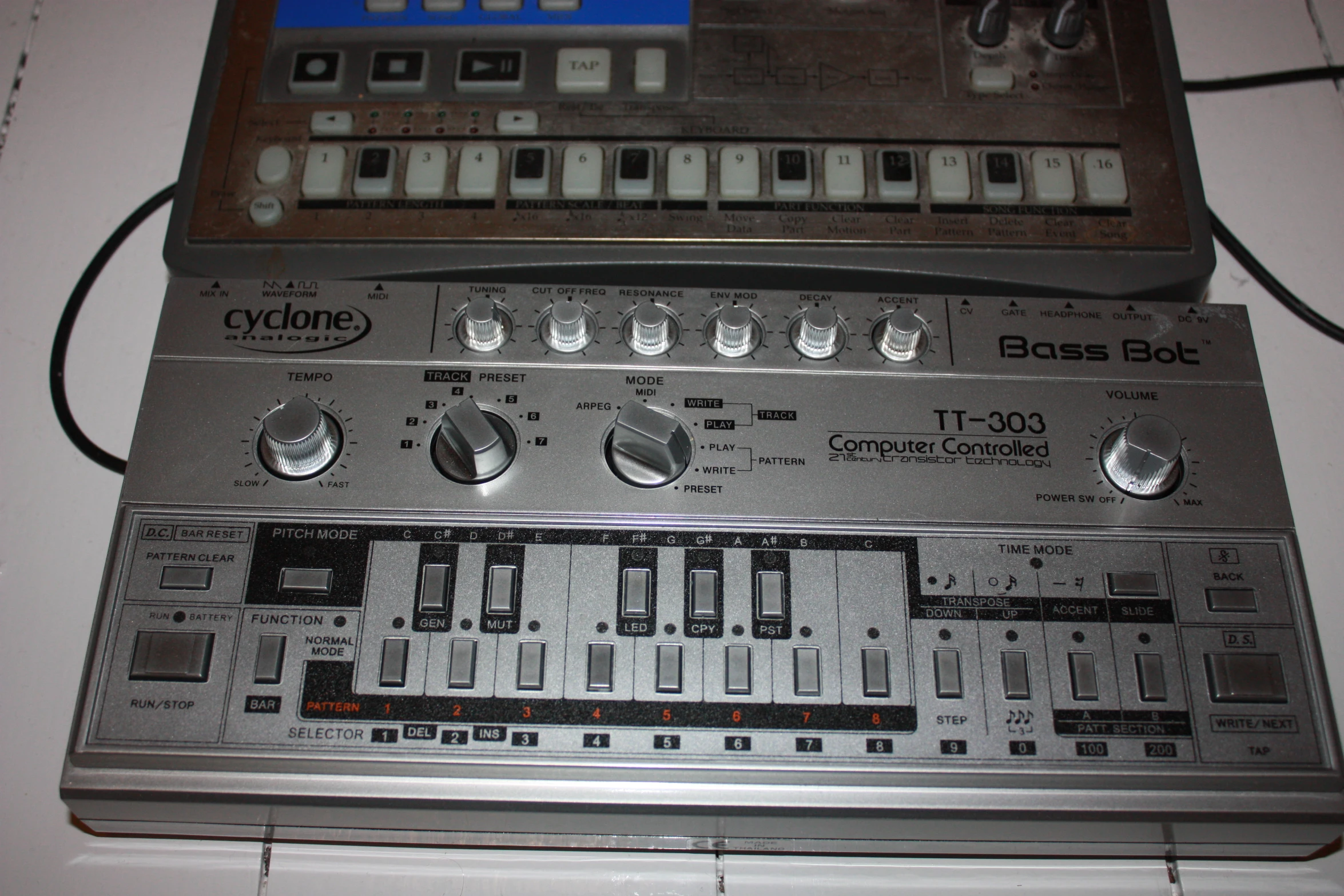 a synthesizer sitting on top of a counter next to two other electronic items