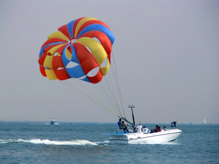 two colorful balloons being pulled by a white boat
