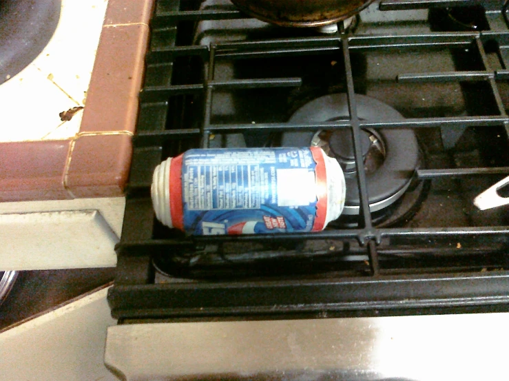 there is a bottle with some liquid sitting on the burners