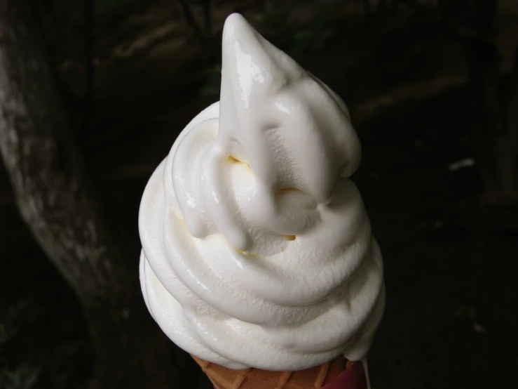 a white frosted dessert is pictured on top of a stick