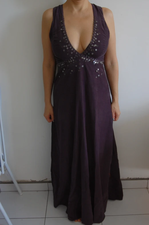 woman standing in purple dress next to a wall