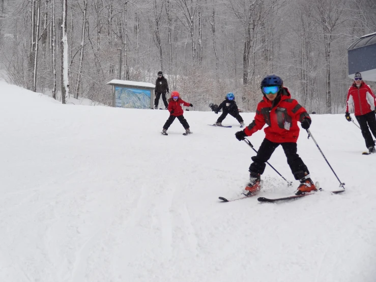 five people are skiing on the snow covered slope